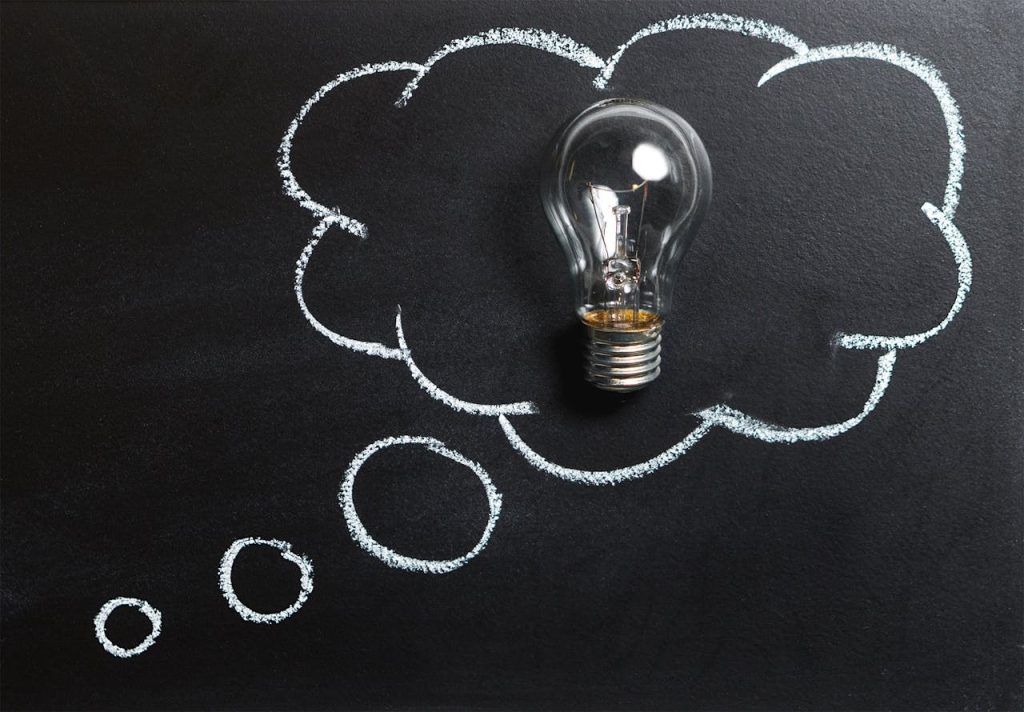 clear-light-bulb-placed-on-chalkboard-355952 Light bulb laying on chalkboard with drawn thought bubble, symbolizing creative ideas.